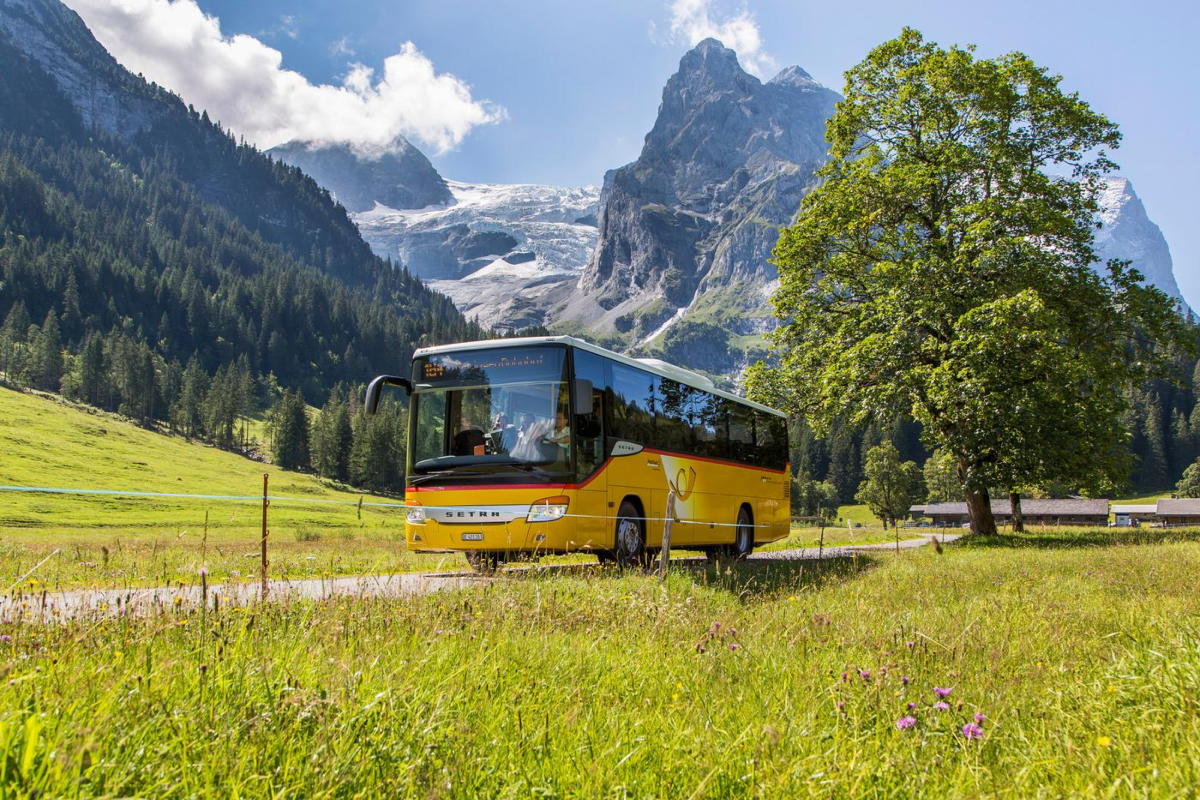 PostAuto bus passing through mountainous countryside